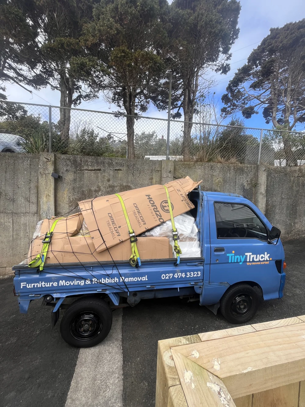 Tiny Truck piled with cardboard boxes and treadmill packaging for a rubbish removal run